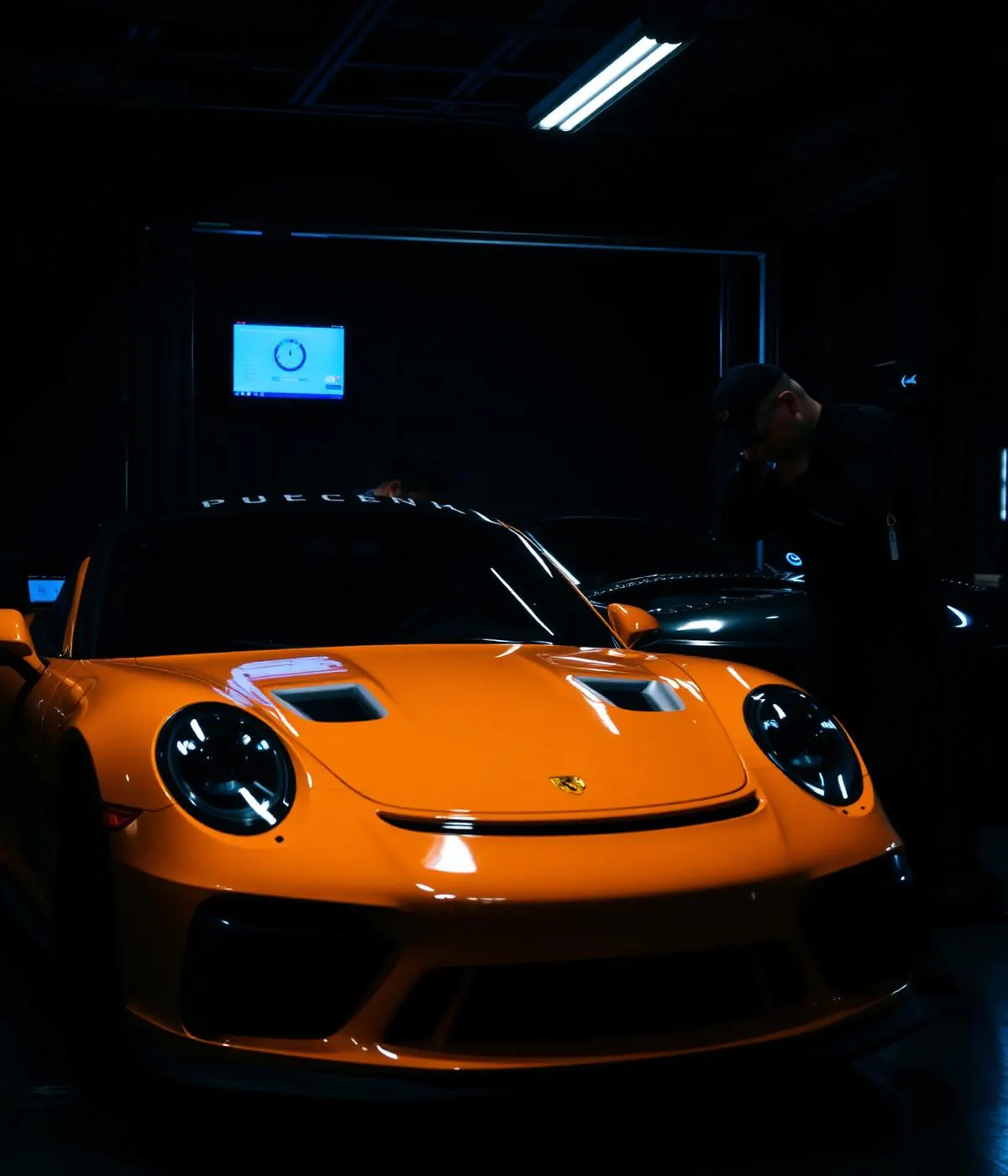 Technician performing diagnostics on a performance car